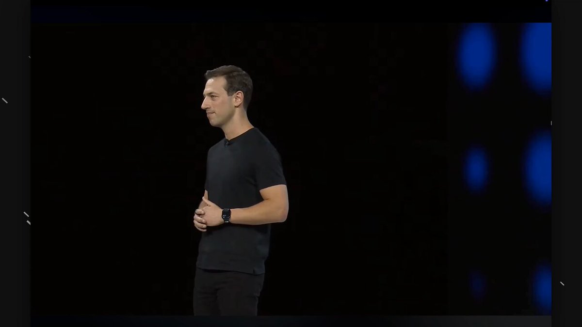 The image shows a man standing in front of a screen with his hands at his sides, possibly giving a presentation or speech. The background appears to be black, which contrasts with the white text displayed on the screen. The caption reads "This is massive for the tokenization industry @coinbase just announced its tokenized stocks product, and no one has really understood its potential yet". This suggests that the image might be related to a recent announcement or development in the cryptocurrency market involving tokenized stocks.