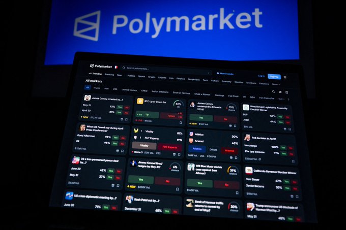 A laptop displays the Polymarket prediction platform with the Polymarket logo visible on a screen behind it, showcasing various active betting markets including "James Comey arrested by...?", "BTC Up or Down for 2024?", "Vitaliy", "Will a less permanent peace deal", and "Jimmy Kimmel fired/indge by May 30?" with percentage odds, illustrating the real-money prediction markets the post references as superior to traditional polling.