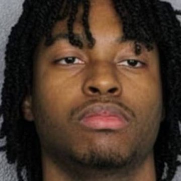 A mugshot-style photo shows a young man with shoulder-length dreadlocks and a goatee, looking directly at the camera with a neutral expression against a plain gray background—likely a depiction of the suspect referenced in the post who allegedly distributed malware through Steam games and stole $382k in cryptocurrency before being identified through Uber Eats gift card purchases.