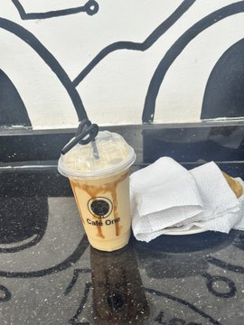 An iced coffee from "Café Crème" sits on a dark surface next to a white napkin, fitting the post's theme of a relaxed Saturday spent outdoors enjoying a casual treat.