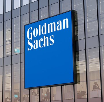 The Goldman Sachs logo is displayed on a building sign, tying into the post which notes that Goldman Sachs has become the largest known holder of spot Solana ETFs with approximately $88.1 million in exposure. The image visually reinforces the news by highlighting the financial giant at the center of this investment milestone.