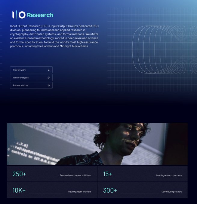 The image shows a website for Bitcoin, featuring a profile of a young man who has been named "i'gleig that cardano's continued research proposal from iog passed on chain that seeks to continue to position cardano as a research leader in the field of web3 and beyond apparently - in the era of ai acceleration/continued exploits left and right across protocols - this". The person is wearing glasses and has an enthusiastic expression. There are two tabs on the image, one titled "i" at the top and another titled "Research", which seem to be part of the content displayed on the site.