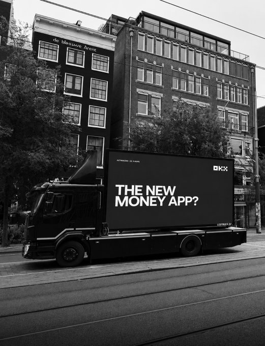 A black-and-white photo shows an OKX-branded truck featuring a digital billboard ad that reads "THE NEW MONEY APP? — AUTHORIZE 24 HOURS — LETTHINK 8 APP" parked on a European street. The "gm" caption pairs with the truck's bold ad campaign positioning OKX as a potential new money app for a new day.