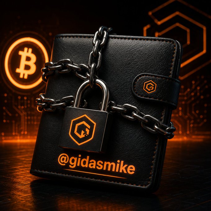 A black leather wallet secured with heavy chains and a padlock features the Bitcoin logo and the text "@gidasmike," symbolizing the locked-down protection of crypto assets. The image reinforces the post's warning about safeguarding seed phrases and wallet credentials in self-custody solutions like MetaMask and OKX Wallet for $CORE holders.