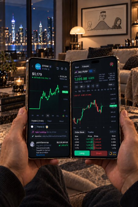 A person holding two foldable phones displaying crypto trading apps with 'STONK' and 'M-PERP' visible, with stock charts and order books on screen against a nighttime city skyline backdrop.