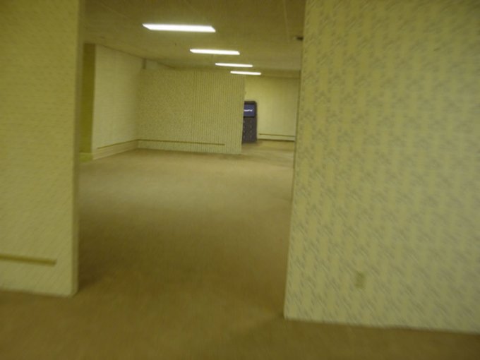 The image shows an empty room with yellow walls, a carpeted floor, and two doors. The room appears to be a storage area or a basement, as there are no people present. A person's face can be seen in the corner of the room, but they do not seem to be interacting with the space. The post about storing Bitcoins is related to this image because it suggests that someone might have stored their Bitcoins in this room and has been referred to as "I was just looking for a safe place to store my cryptos... Not sure how I ended up here".
