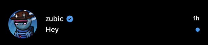 A screenshot of a Facebook message notification from verified user "zubic" containing the single word "Hey," sent 1 hour ago and marked as unread. The user's profile picture shows a blue robot character wearing a hat.