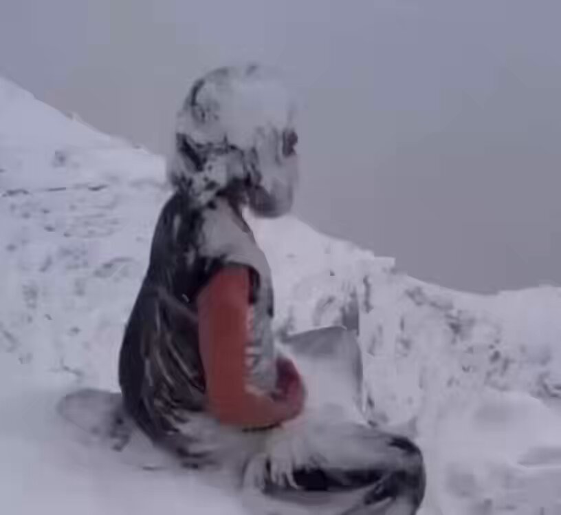 The image shows a person sitting on a snowy mountain, with their face covered in snow. They are holding a book or a piece of paper while wearing a black shirt. The surrounding area appears to be covered in snow as well. There is also text present in the image that reads "XRP to $589 they said it'll be quick". This suggests that the person might have been discussing cryptocurrency, possibly Bitcoin, with someone else who was involved in the transaction.