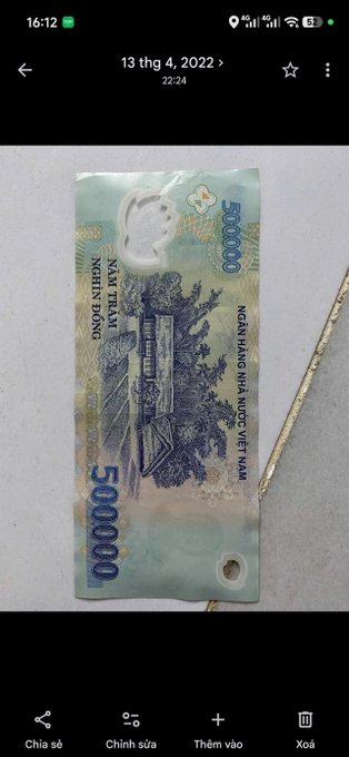 A photograph of a wet, damaged 500,000 Vietnamese Dong banknote displayed in a mobile phone gallery app, dated 13 thg 4, 2022.