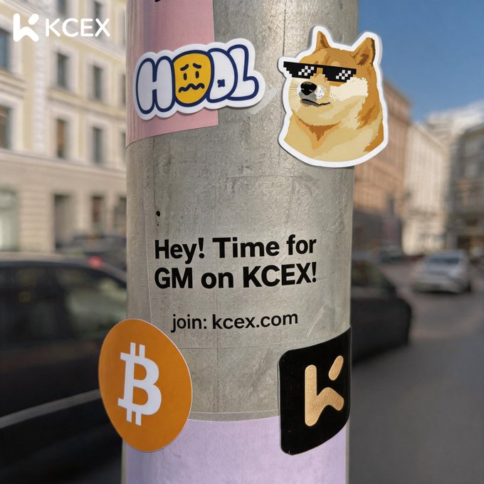 A pole covered in stickers, including a Bitcoin logo, a Doge meme, and text reading 'Hey! Time for GM on KCEX! join: kcex.com' with a KCEX logo in the corner.