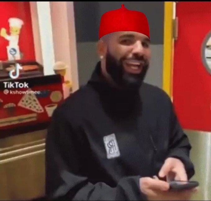A bearded man wearing a red fez cap and black hoodie smiles while holding a phone in what appears to be a pizzeria, with a TikTok watermark "@kshowtime" visible. The image relates to the post's warning about crypto/NFT projects being delisted, serving as a visual caution ("shine your eyes") to viewers about suspicious projects.