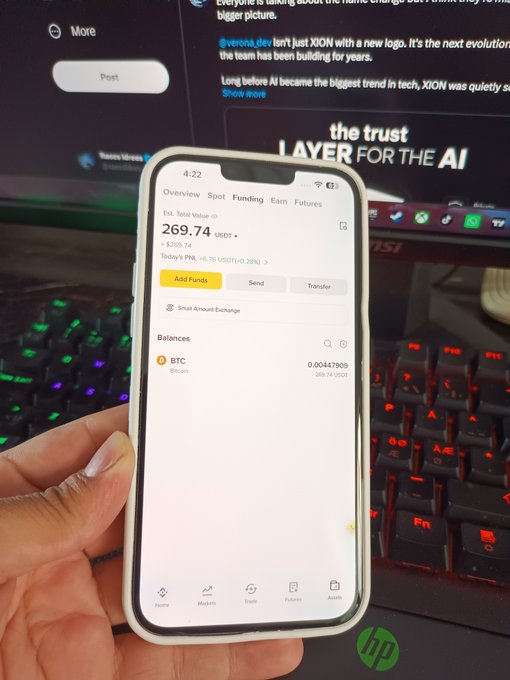 A hand holds a phone showing a crypto portfolio with a BTC balance of 0.00447909 (~$269.74 USDT) and a floating loss of -22.29 USDT, illustrating the day 29 update of a $10 daily BTC buying streak bought at $60,130 with an average price of $65,200.