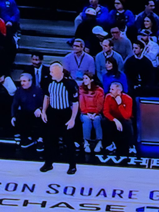A referee standing on the court at Chase Center (home of the Golden State Warriors) with spectators seated behind him in the stands.