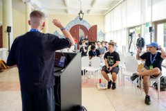 The speaker gestures while presenting to a seated audience in a bright, modern venue, with one attendee notably wearing a green shirt. The image captures the energy of the @ETHGlobal Lisbon hackathon mentioned in the post, illustrating the speaker's positive impression of the event's high-quality submissions.