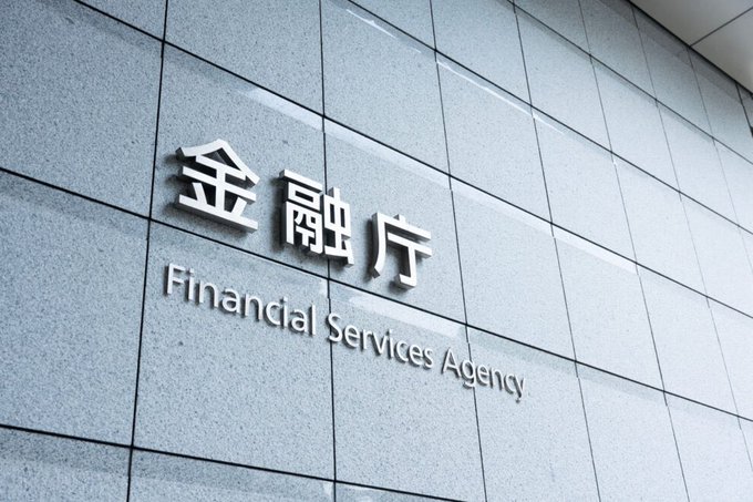 The image shows the exterior signage of Japan's Financial Services Agency (FSA/金融庁) displayed in both Japanese and English on a tiled wall, directly relevant to the agency's announcement establishing a new Crypto Assets and Stablecoins Division.
