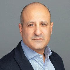 A headshot of Joseph Chalom, CEO of SharpLink, pictured against a gray background in a dark blazer and light blue button-down shirt. The image accompanies news about his comments on Ethereum's dominance in security, trust, and liquidity for institutional investors.