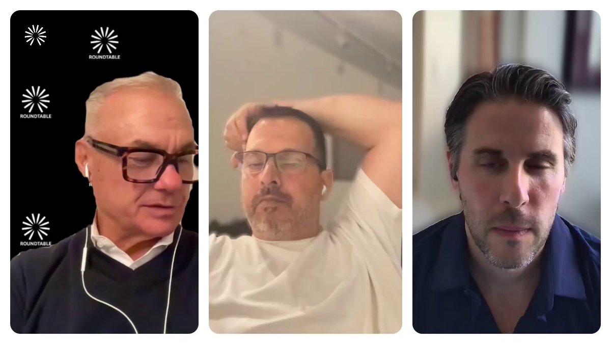 The image shows three men with glasses, each wearing a different colored shirt - white, blue, and black. They are all sitting down and appear to be engaged in a video call or online meeting. The background of the image features a gray wall adorned with white flowers, which adds an artistic touch to the scene. The caption for the image reads: "Coinbase backs Roundtable's AI-powered, DeFi Media Platform. This deep integration represents what we believe to be the single most powerful asset available."