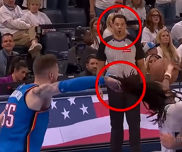 The image shows a basketball game with two teams playing against each other, one wearing blue jerseys and the other wearing white. A referee is present, possibly making a call or giving instructions during the game. The crowd of spectators can be seen watching from various positions around the court. There are also two red circles in the middle of the image, which could potentially represent the basketball hoop or another element related to the game.