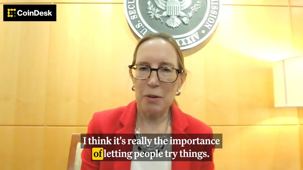SEC Commissioner Hester Peirce, often called "Crypto Mom," is shown speaking in front of the SEC seal, with the CoinDesk logo in the corner and a subtitle reading, "I think it's really the importance of letting people try things."