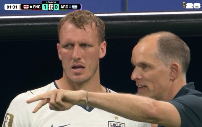 A close-up from a soccer match showing two men, one in a white jersey (ENG) gesturing seriously while another points to the left, with the scoreboard reading "ENG 1 - 0 ARG" at 81:31 and a "26" World Cup trophy logo visible. The image humorously captures the intense, serious expression and pointing gesture, which the post compares to a financial advisor warning about the dangers of meme coin investments.
