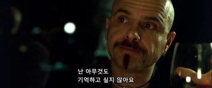 A close-up of a bald man with a mustache looking intently off-camera, with Korean subtitles reading "난 아무것도 기억하고 싶지 않아요" (I don't want to remember anything). The image's expression of denial or avoidance of memory mirrors the post's discussion of Bitcoiners dismissing the trustworthiness of device-generated seed phrases, choosing instead to avoid self-custody altogether.