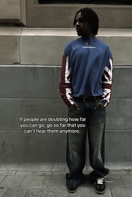 A man with dreadlocks stands against a gray wall wearing a blue and red layered shirt, accompanied by the text: 'If people are doubting how far you can go, go so far that you can't hear them anymore.'