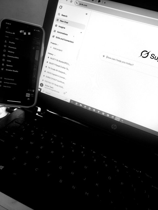 A black-and-white image shows an HP laptop displaying the Grok AI interface (grok.com) alongside a smartphone, with an inspirational caption about perseverance and seeking good fortune through continued effort. The workspace setup visually reinforces the caption's theme of "getting started again" with the AI chat ready for new questions, embodying the mindset of moving forward despite uncertainty.