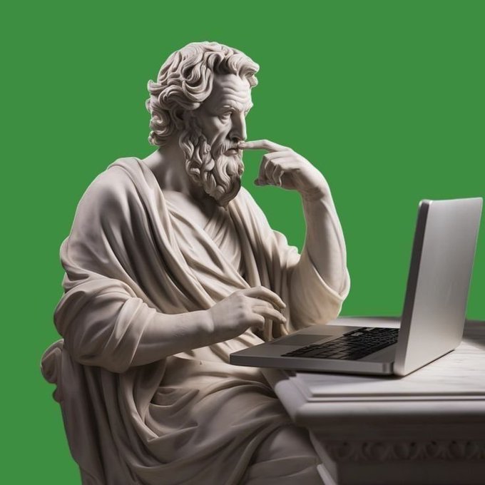 A marble statue of a classical bearded philosopher in robes, sitting at a desk and thoughtfully using a modern silver laptop against a bright green screen background.