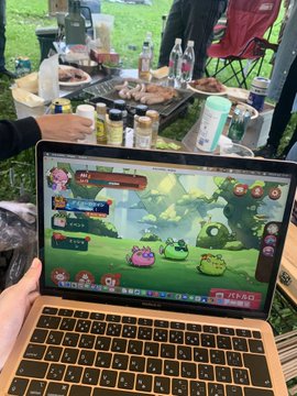 A person plays "Fantasian" on a laptop at an outdoor picnic setting with drinks and snacks visible in the background. The image illustrates the post's sentiment about games finding creative workarounds to avoid server shutdowns, with "Fantasian" being a notable example of a game that bypassed its planned discontinuation through new management and reissued tokens.