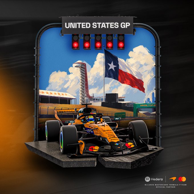 A McLaren Formula 1 car sits on a display beneath a sign reading “UNITED STATES GP,” with a Texas flag, track tower, red lights, and McLaren/Hedera branding.