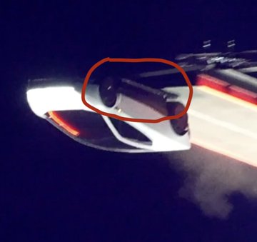 A nighttime image shows a modern car's rear taillight and bumper area, with a red circle highlighting an interior compartment, possibly a charging port or fuel door, that the user included to add context to their highly-viewed cryptocurrency post on X.
