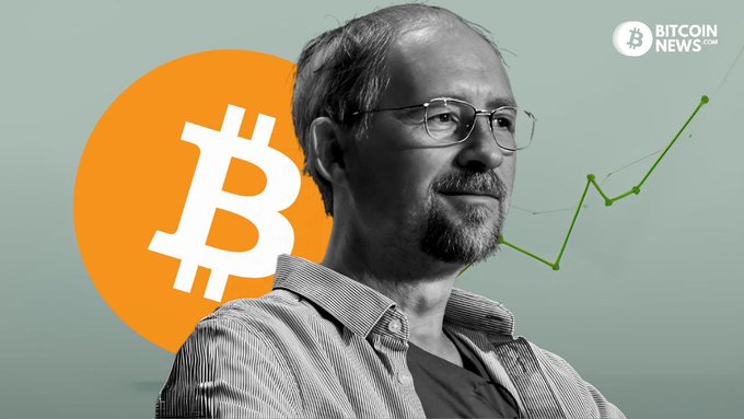 A black-and-white photo of a bespectacled, bearded man (Adam Back, CEO of Blockstream) appears alongside an orange Bitcoin logo and a rising green line graph, with "BITCOIN NEWS.COM" watermark in the corner. The image illustrates the Blockstream Liquid Network exploit story, showing the company's leader as the firm refuses to pay ransom for stolen bitcoin.