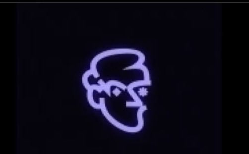 A glowing neon sign of a stylized smiling face with a pompadour hairstyle on a dark wall.