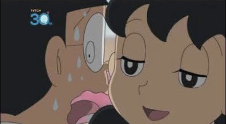 A screenshot from the Japanese anime Doraemon showing two characters looking at each other with wide eyes and flushed faces.