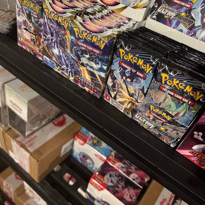 Booster packs of Pokémon Trading Card Game sets, including Astral Radiance and Ultra Beasts, displayed on store shelves for collectors to rip open at BONKUJI.