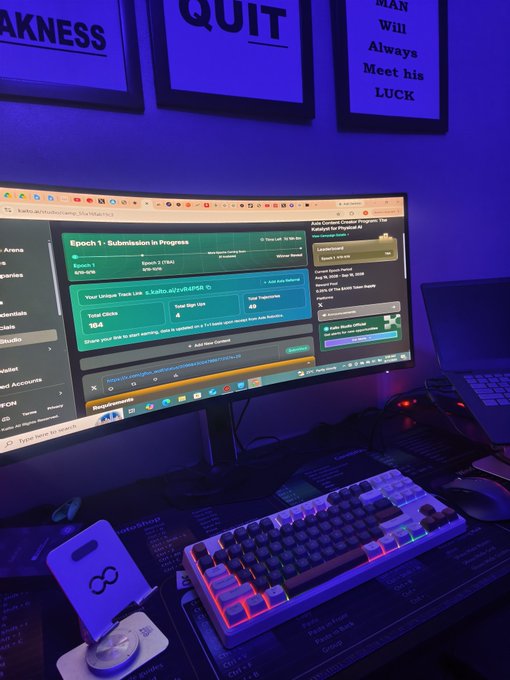 A dimly lit gaming or work setup features a curved monitor displaying a physical activity submission page for an event called 'Epoch 1 - Submission in Progress,' accompanied by an RGB mechanical keyboard and framed motivational wall art reading 'QUIT' and 'MAN WILL Always Meet his LUCK'.