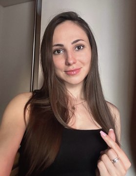 A smiling young woman with long brown hair wearing a black top takes a selfie, showing a ring on her finger to celebrate a successful art sale, expressing gratitude to her buyers @Alex_NFT_777 and @Ying819.