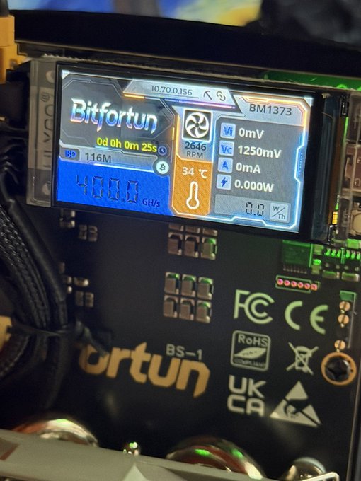 A Bitfortun BM1373 cryptocurrency mining device displays a hash rate of 400.00 GH/s with temperature and voltage readings.