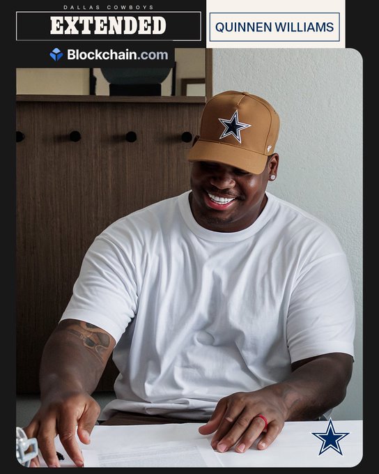 Quinnen Williams, wearing a Dallas Cowboys cap, smiles as he signs a contract, with on-screen graphics announcing his extension alongside "Blockchain.com" branding. The image captures the moment referenced in the post celebrating his signing with the team.