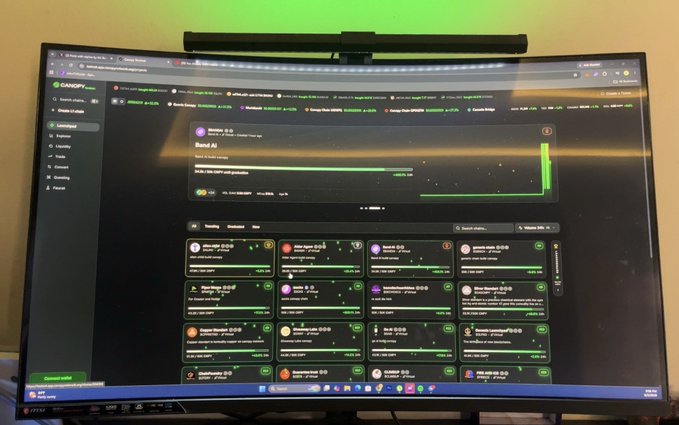 Photograph of a curved monitor displaying the Gate.io Launchpad/Hodl Airdrop page with various crypto token airdrop listings.