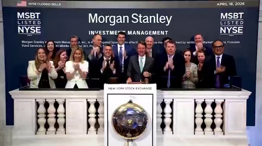 The image shows a group of people standing behind a desk, clapping their hands together for a photo. They are surrounded by banners that display names such as Morgan Stanley, listed exchange, investment management, and New York Stock Exchange, along with other financial terms like $10 trillion and Bitcoin. The text in the post suggests there is an event where Morgan Stanley has added another billion to its assets. The people in the group could be attending a celebration or commemorating an achievement at the company's headquarters, as indicated by their enthusiastic clapping and standing close together.