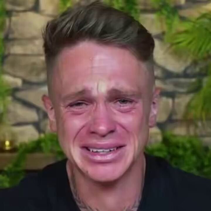 The image shows a man with a shaved head, wearing a black shirt, who appears to be crying or upset. He has a tattoo visible on his neck. The caption reads "When I see one of the homies start trading on BASE". This suggests that there might have been an incident involving a trading platform where the man's name was mentioned in relation to a base exchange.