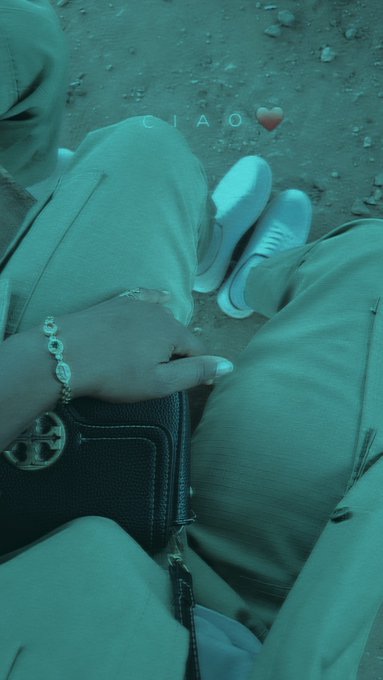 Two people sit closely together with a dark handbag resting on their lap, their hands and white sneakers visible against a pebbled ground. The teal-tinted photo is overlaid with the word "CIAO" and a red heart, complementing the post's enthusiastic call to build the agentic economy on the Arc network.