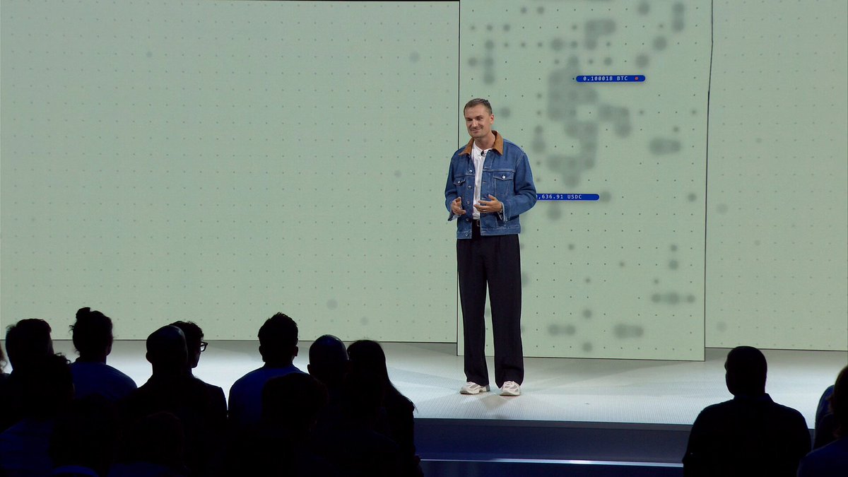 The image shows a man standing at a podium, giving a speech or presentation to an audience of people sitting behind him. The setting appears to be indoors with white walls, suggesting that this could be a conference or event taking place in a large room. The speaker is dressed casually and wearing a blue jacket. The post reads "We're coming to desktop. We're adding more chains. We're adding new markets." This indicates that the man's speech might be related to business or technology, possibly discussing the evolution of desktop computers and their impact on various industries.