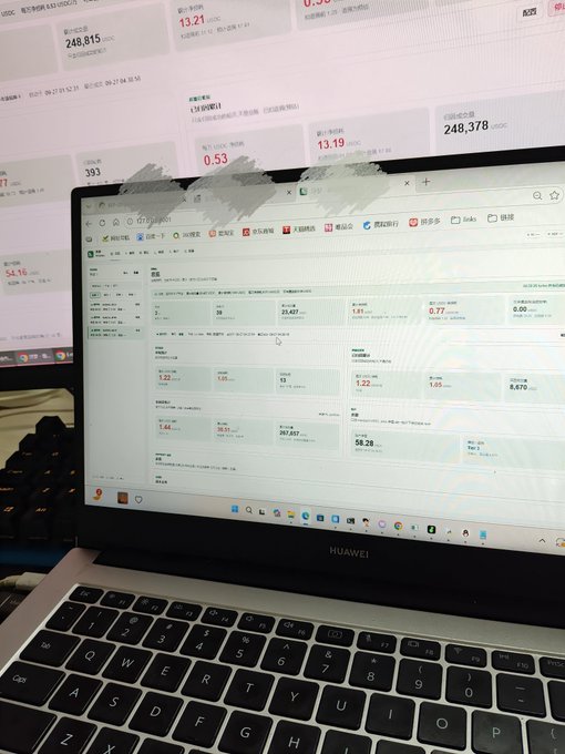 A Huawei laptop displays a financial dashboard with various data tables and metrics, set against a background monitor showing cryptocurrency or stock prices including '249,815', '13.21', and '248,378'.