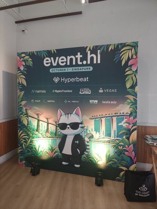 An event backdrop reading 'OCTOBER 7 - SINGAPORE' for 'event.hl' featuring a cartoon cat in sunglasses, with sponsors including Hyperbeat, HyperTracker, Odd Hours, and VEGAS, alongside a 'THE HUNT OF SINGAPORE' bag.