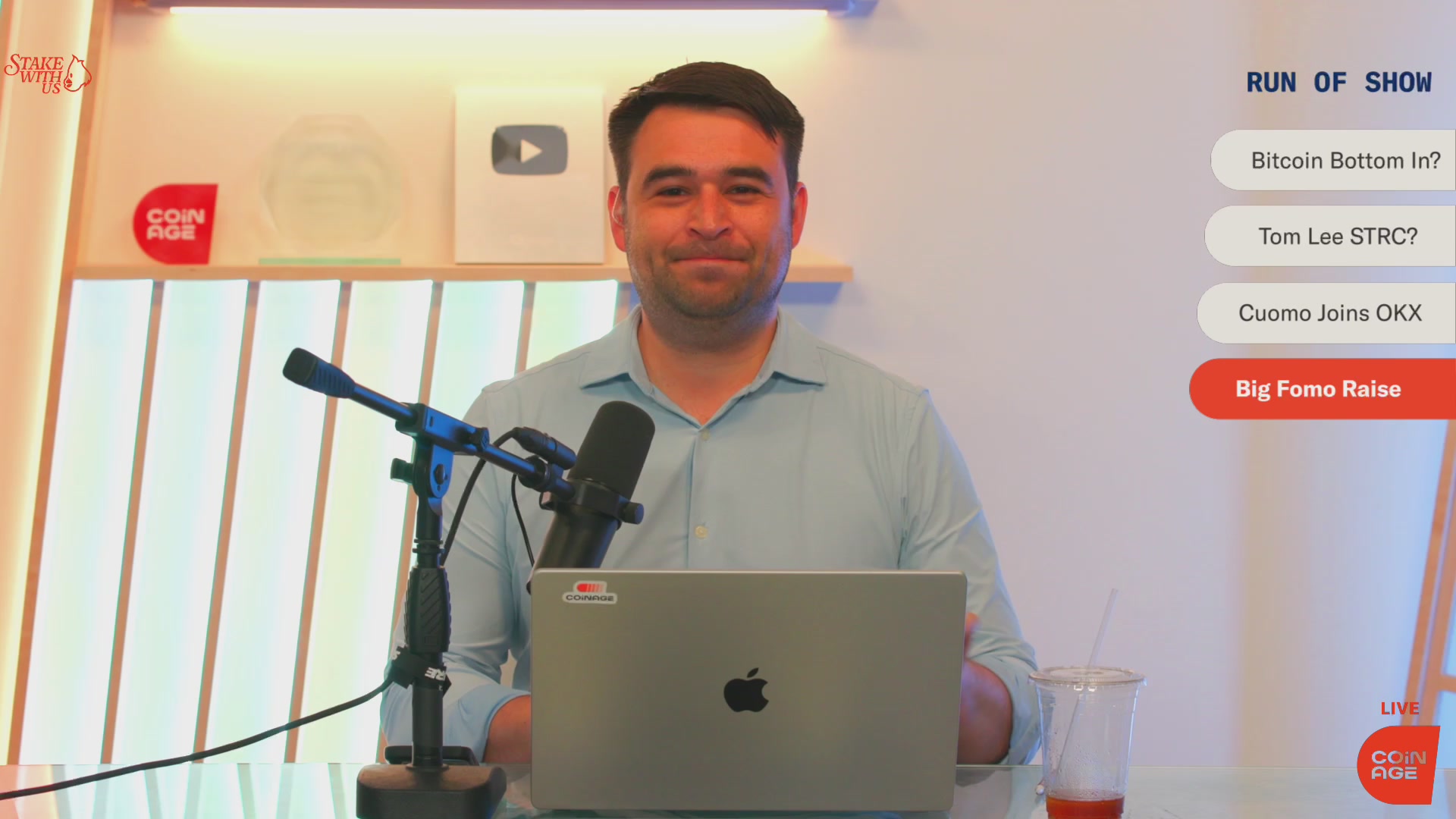 The image shows a man sitting at a desk with an open laptop computer. He appears to be wearing a blue shirt, and there are two microphones placed near him - one on his left side and another on his right side. The background of the image features a white wall with a window that allows natural light into the room. There is also a cup located next to the man's desk.

The post in question discusses Bitcoin and its recent rebound, as well as the potential risks associated with it. It seems to be an exploration or analysis of the cryptocurrency market, possibly related to the Bitcoin podcast being discussed on the show. The image captures the moment when the host is talking about Bitcoin, and the man sitting at his desk appears to be listening intently while working on his laptop.
