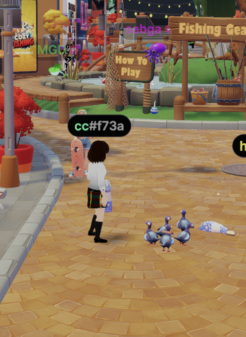 A Decentraland avatar stands in a vibrant virtual plaza named "sebga," with a fishing gear shop and "How To Play" sign nearby, while feeding digital pigeons with a name tag reading "cc#f73a." The scene captures the playful newcomer experience of exploring the metaverse and interacting with its quirky elements.