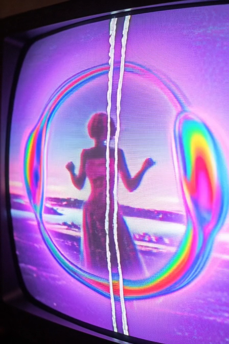 A stylized image showing a silhouette of a woman inside a soap bubble, displayed on what appears to be a CRT screen with vertical distortion lines and a purple/pink color palette.