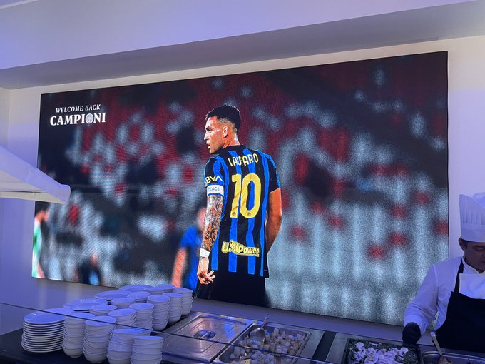 A large welcome screen displays 'WELCOME BACK CAMPIONI' featuring Inter Milan's Lautaro (#10) in their blue and black kit, set above a buffet area with stacked plates and chefs.